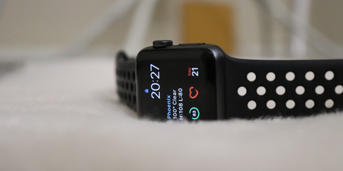 Photo shows black smartwatch on white plush background